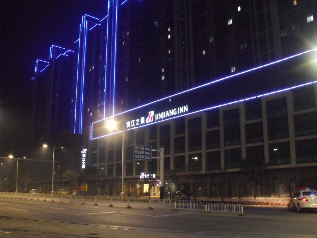 un edificio con un cartel en su costado por la noche en Jinjiang Inn Bengbu High-Railway Station Shengli Road, en Bengbu
