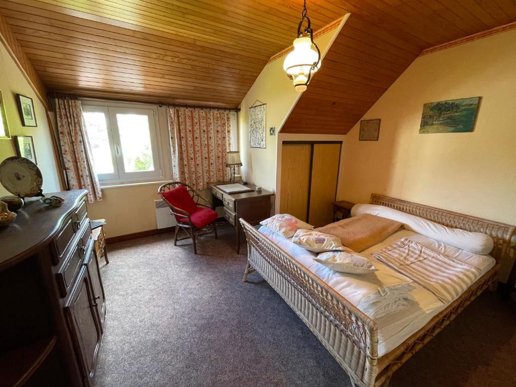 a bedroom with a bed and a desk in it at Maison vintage en bord de mer in Loctudy