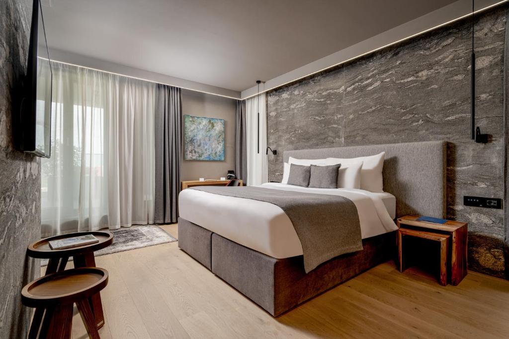 Un pat sau paturi într-o cameră la Qosmo Brasov Hotel