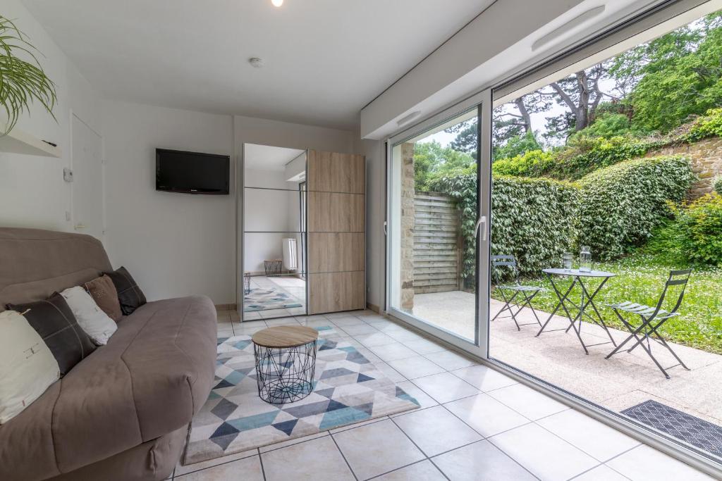 un salon avec un canapé et une terrasse dans l'établissement Studio Chateau Limoges Vannes, à Vannes