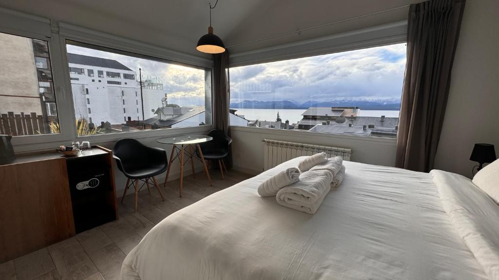 a bedroom with a large bed with a large window at Hotel Patagonia Signature in San Carlos de Bariloche