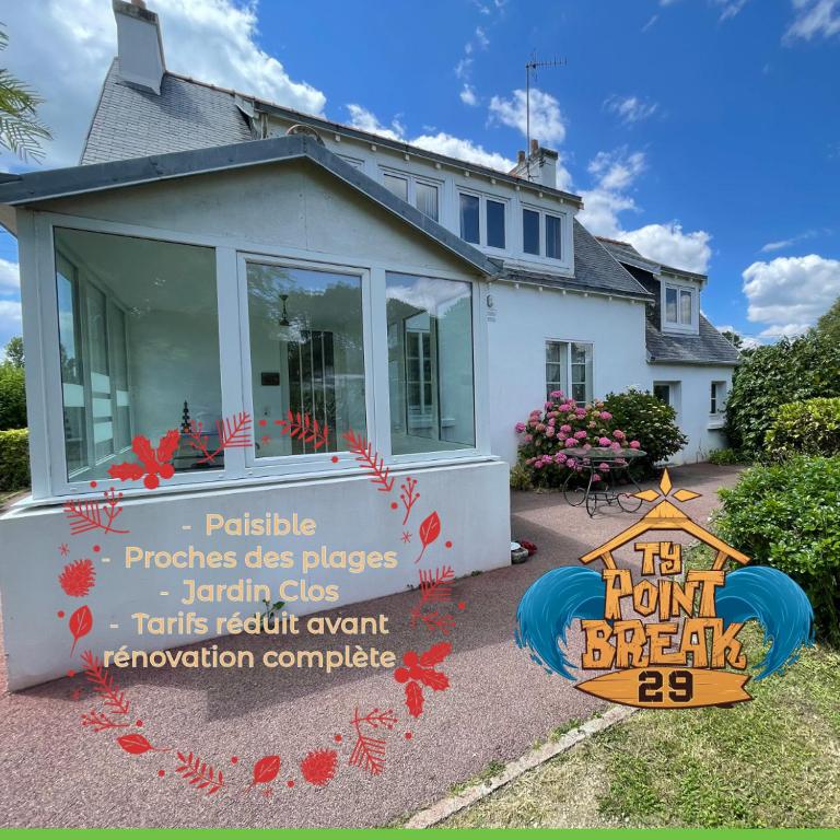 une maison avec un panneau devant une maison dans l'établissement Maison vintage en bord de mer, à Loctudy