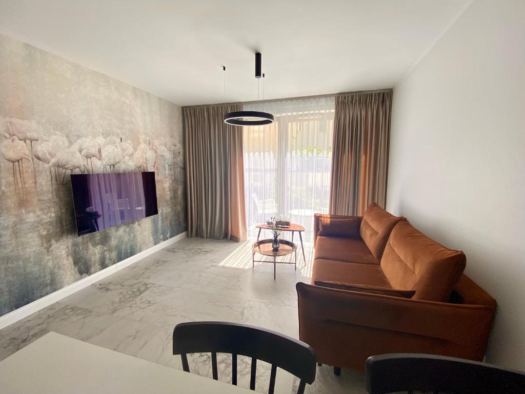 a living room with a couch and a tv at Apartament Środowa 6 by Prestige Home in Szczecin