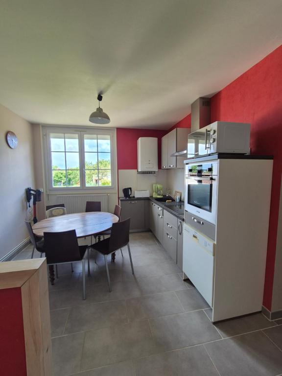 une cuisine avec une table et une salle à manger dans l'établissement Le Mamy Blue, à Paray-le-Monial