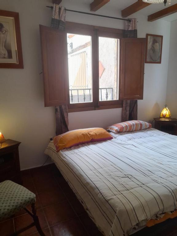 a bedroom with a large bed with a window at Habitacion en Casa Huelves in Huelves