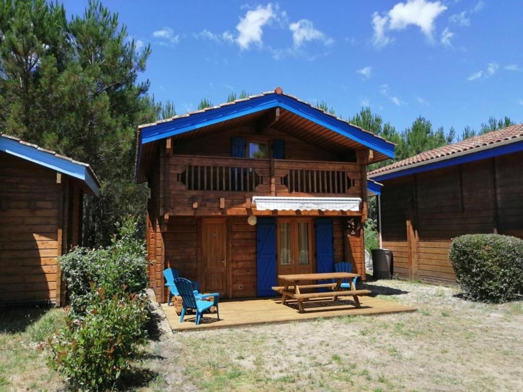 a log cabin with a picnic table and a bench at CHALET 5p tout confort bias mimizan dans village vacances in Bias