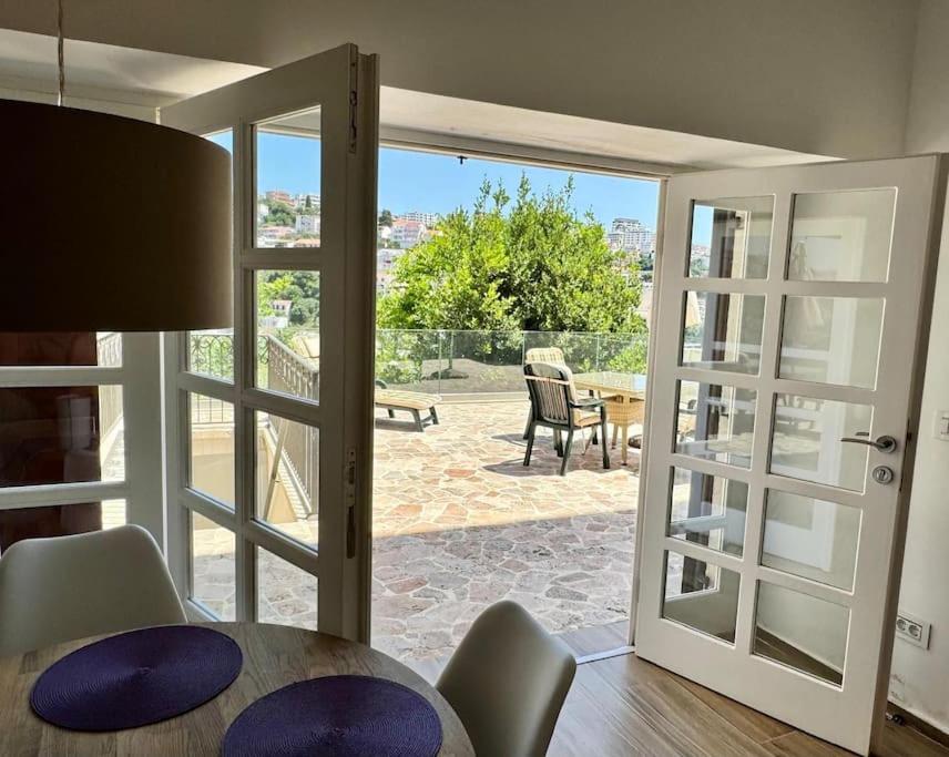 a dining room with a table and a sliding glass door at Ulcinj - Stonehouse in Oldtown with sea view in Ulcinj