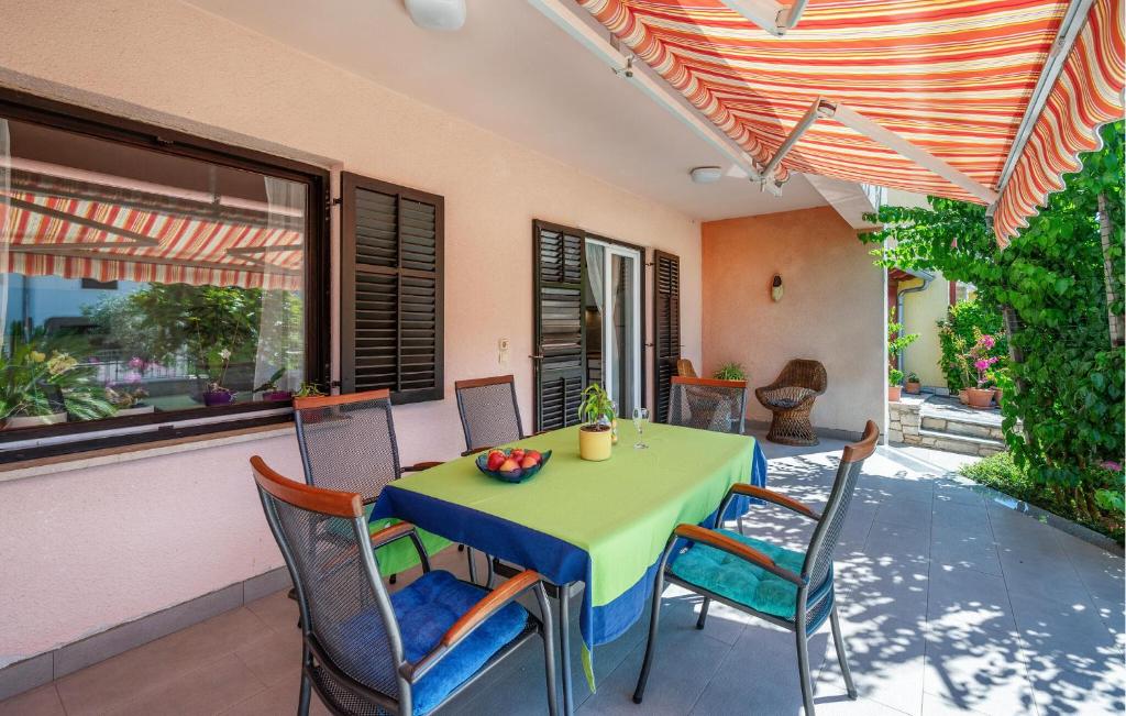 a green table and chairs on a patio at Nice Apartment In Valbandon With Wifi in Valbandon