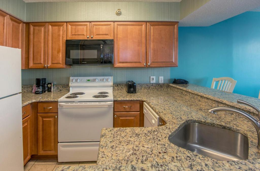 a kitchen with a white stove and a sink at The Strand - A Boutique Resort in Myrtle Beach