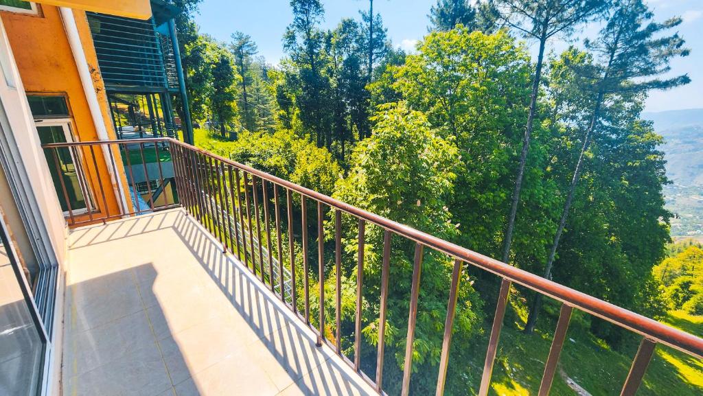 a balcony of a house with a view of trees at Aqua Apartment Murree in Murree