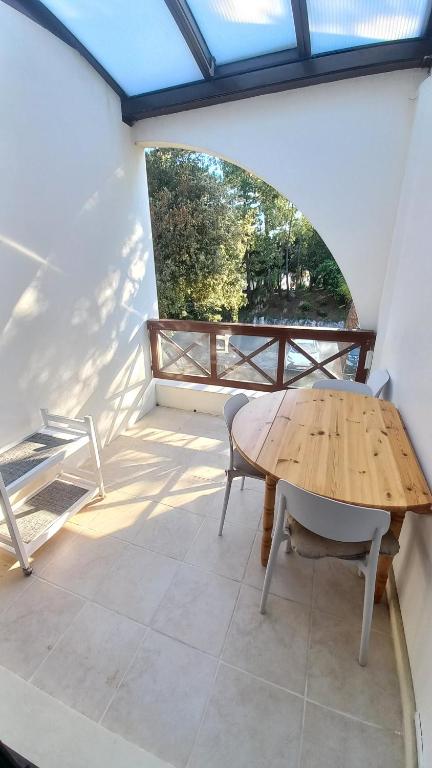 d'une terrasse avec une table et des chaises en bois sur un balcon. dans l'établissement Entre plage et forêt - Agréable T3, à Saint-Georges-de-Didonne