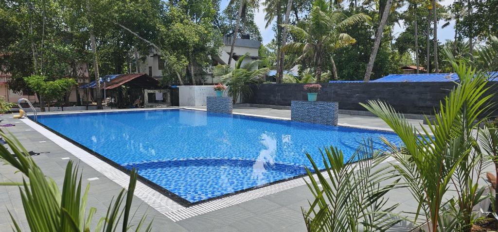 a large blue swimming pool in a yard at LEISURE VALLEY BEACH RESORT in Varkala