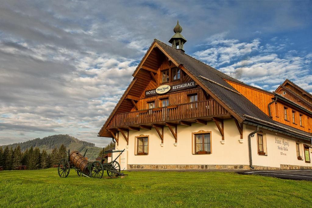 budynek z powozem ciągniętym koniem przed nim w obiekcie Hotel Rankl w mieście Horská Kvilda