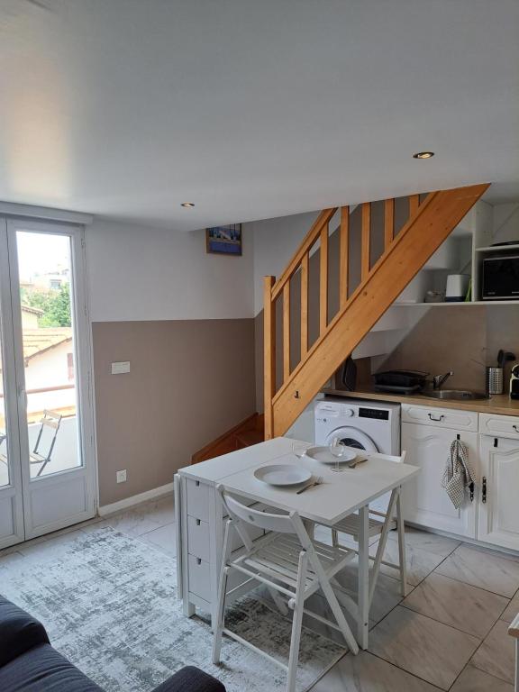 une cuisine avec une table blanche et un escalier dans l'établissement 2 pieces en Duplex à 5 minutes de la plage N2, à Saint-Laurent-du-Var