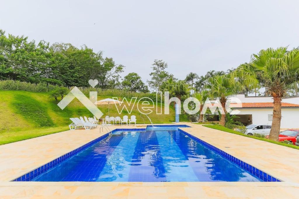a villa with a swimming pool and a house at Linda chacara em Mogi das Cruzes in Mogi das Cruzes