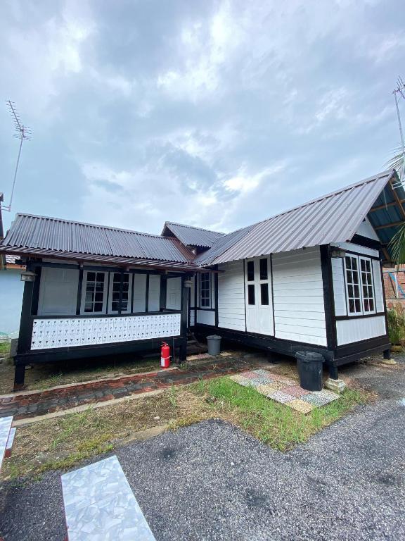 a white house with a metal roof at Nami Homestay Teluk Batik in Lumut