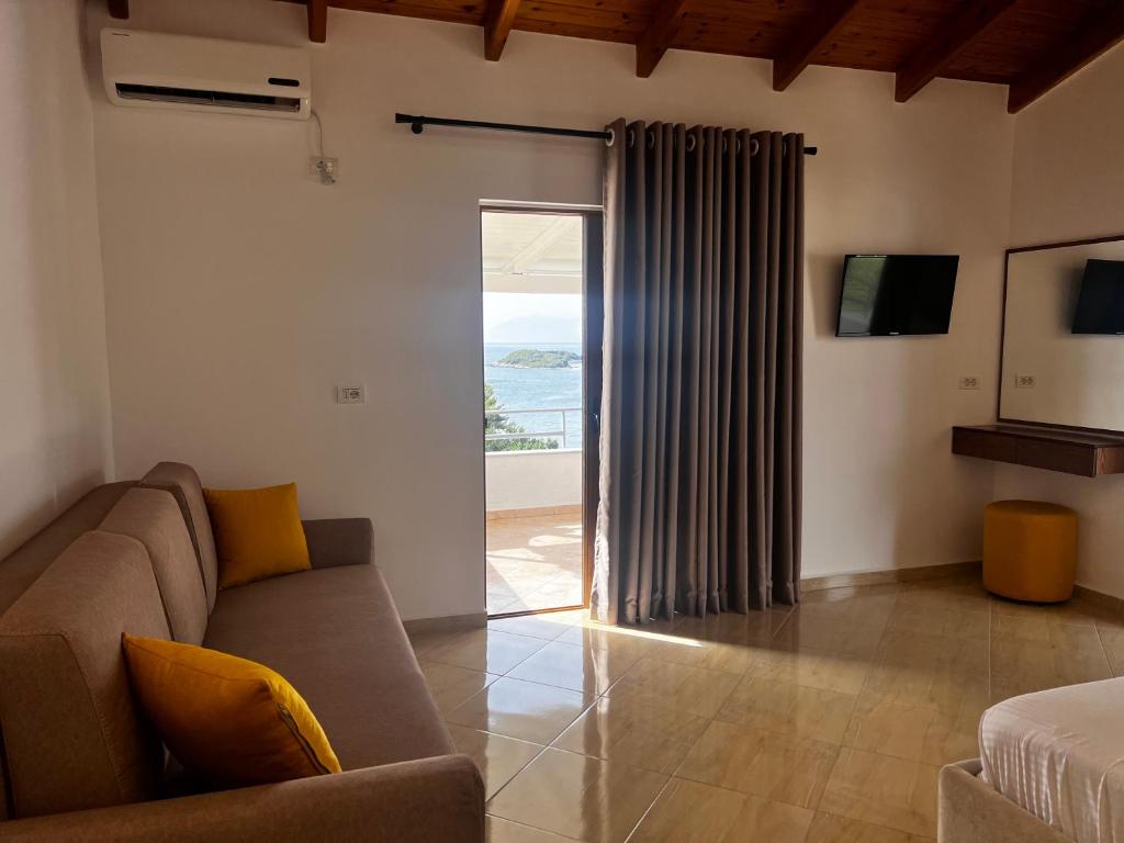 a living room with a couch and a sliding glass door at Dine Hotel in Ksamil