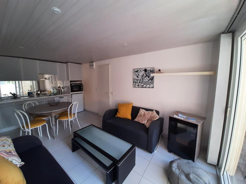 a living room with a couch and a table at Le Val Rose 150m de la mer in Jullouville-les-Pins
