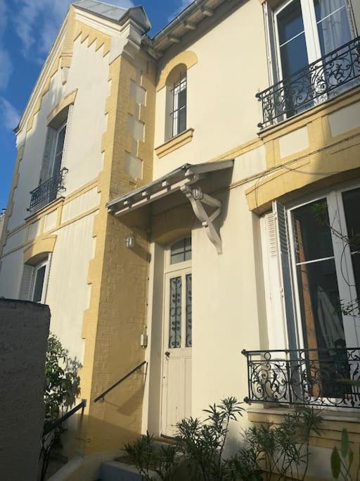 - un bâtiment blanc avec une porte et un balcon dans l'établissement Charmante maison au calme, à Colombes