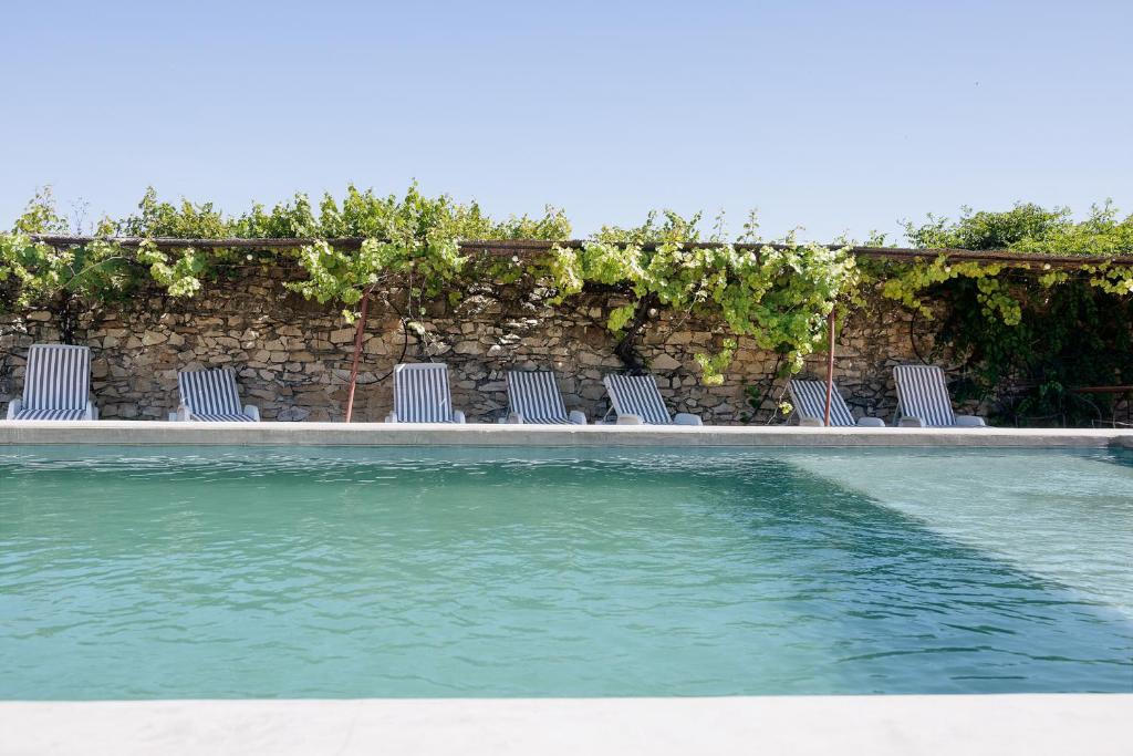 une rangée de chaises assises à côté d'une piscine dans l'établissement La Glacière, ostalarià agricol, à Tresques