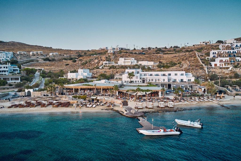 two boats in the water next to a beach at Hippie Chic Hotel in Agios Ioannis Mykonos
