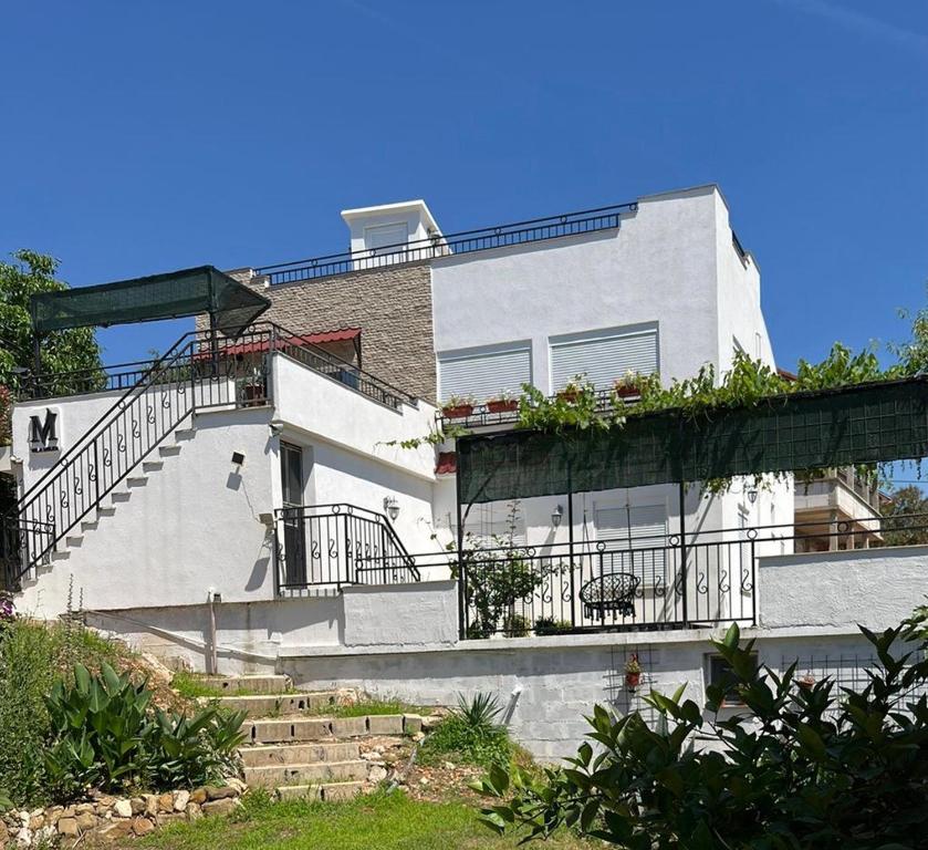 a white house with stairs and plants on it at Villa Milka in Utjeha