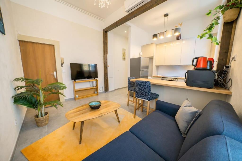 un salon avec un canapé bleu et une table dans l'établissement Le Pampille, Grand T2, Climatisé, Centre ville, à Montpellier