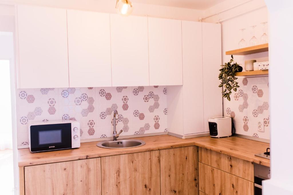 a kitchen with a sink and a microwave at Riverside White Apartment in Satu Mare
