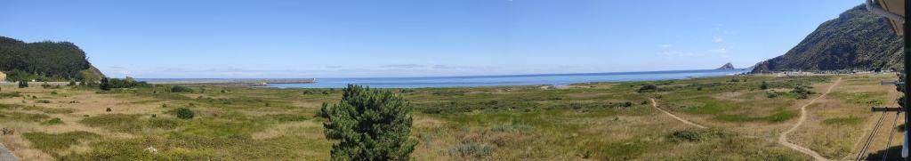 a view of a field with the ocean in the background at Apartamento Mirando al Mar in San Juan de la Arena