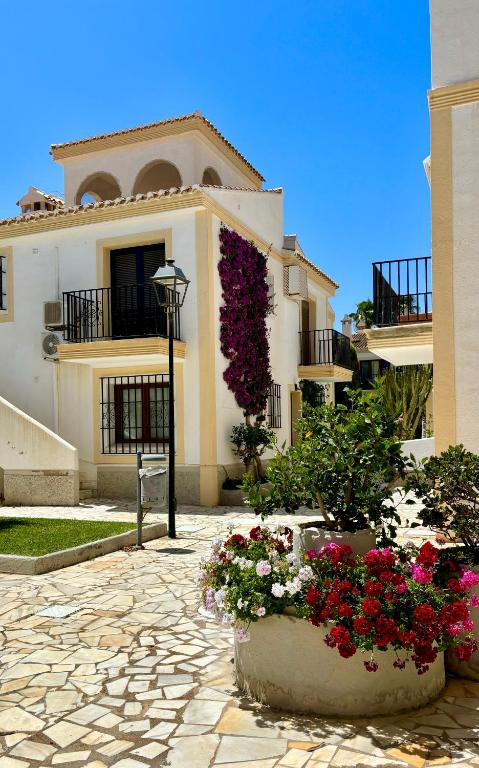 a large building with flowers in front of it at Casa Veranera Vera Costa in Playas de Vera