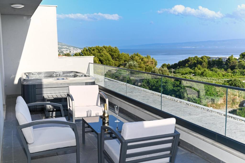 a balcony with a grill and chairs and the ocean at Luxury Apartment Skyline in Split