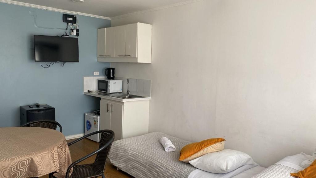 a room with a table and a couch and a microwave at Mirador I in Puerto Varas