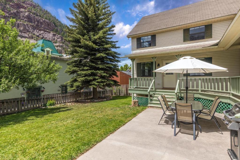 a patio with a table and chairs and an umbrella at 320 8th Avenue in Ouray