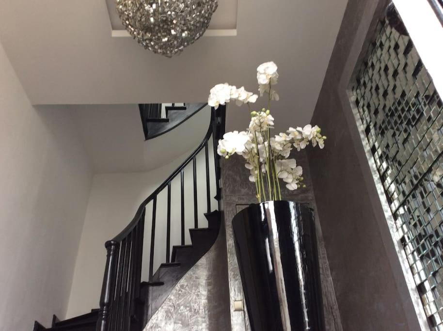un vase avec des fleurs blanches dans un escalier dans l'établissement Charmant STUDIO, à Valenciennes