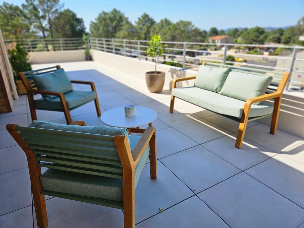 un patio avec deux chaises et une table sur le toit dans l'établissement Appartement de standing Lema- clim-wifi- 3 chambres, à Lecci