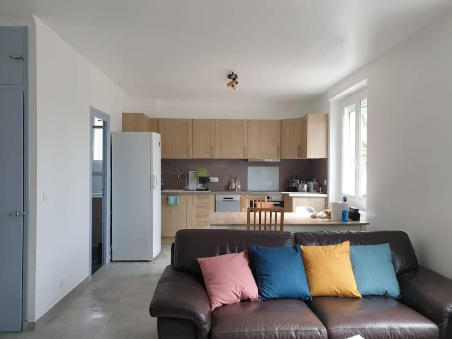 - un salon avec un canapé marron et des oreillers colorés dans l'établissement La vie est un reve, à Blois