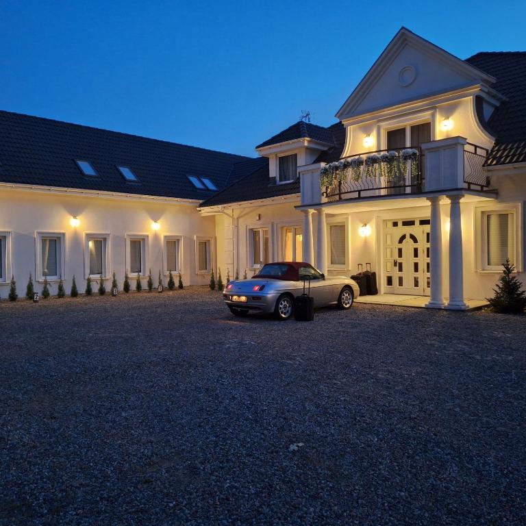 a car parked in front of a house at night at Dworek MARINO KOŁOBRZEG in Grzybowo