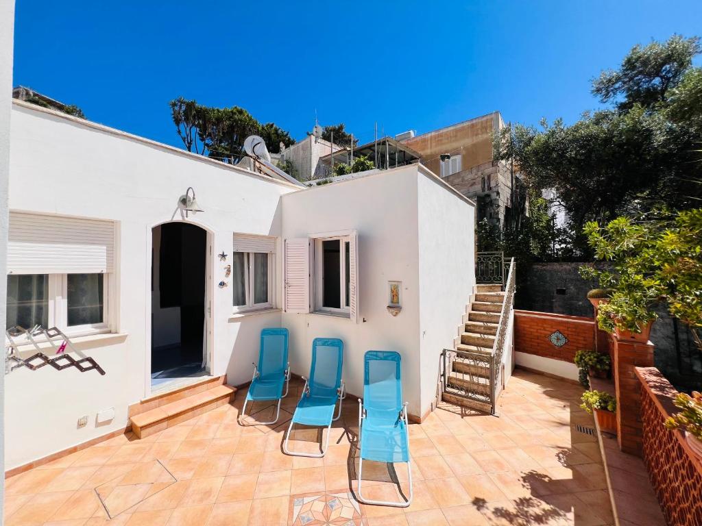 a patio with four blue chairs on a house at Casa Francesca - Immobilevante in Ponza
