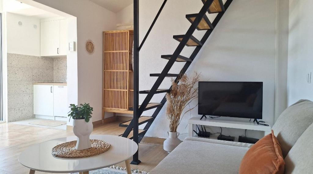 a living room with a staircase and a tv at Aloft Apartment in Budva