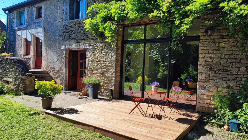 une terrasse en bois avec 2 chaises dans l'établissement Calme et confort à la campagne en Bourgogne vinicole,, à Aubigny-la-Ronce