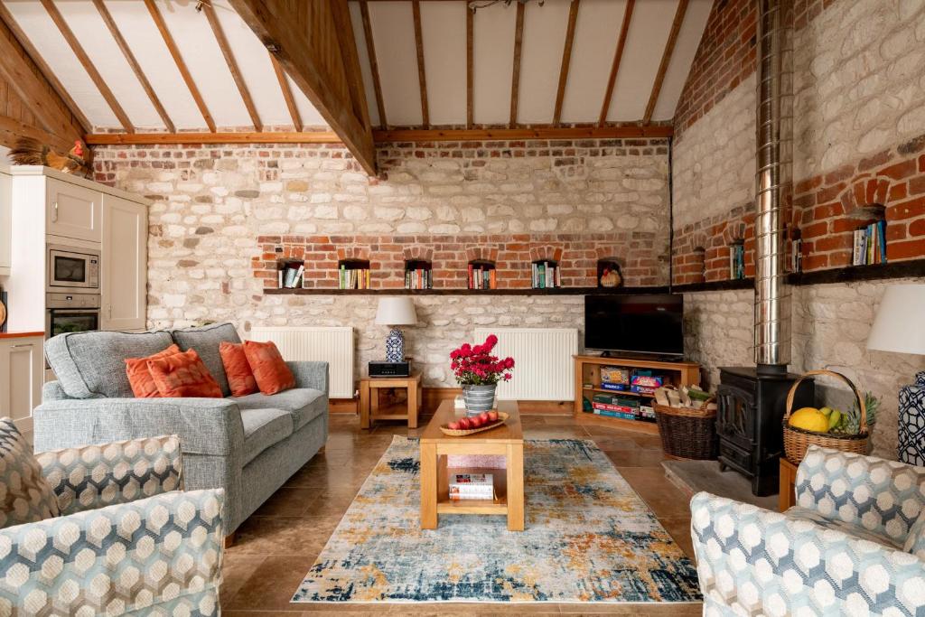 Una sala de estar con dos sofás y una mesa. en The Roost, Heritage Escapes, Field House Farm, en Bempton