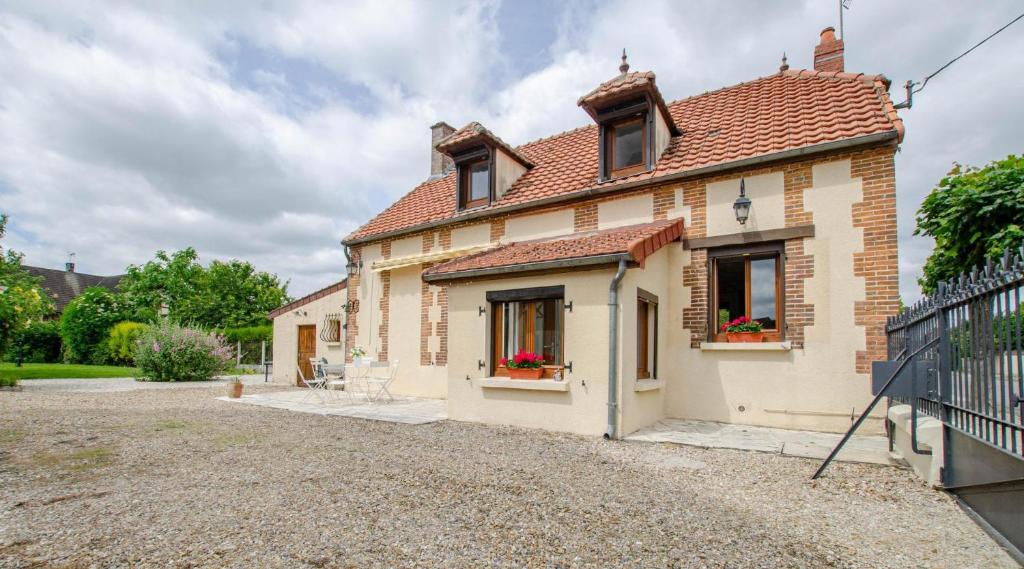 a brick house with two windows and a driveway at Le refuge de poussey in Maizières-la-Grande-Paroisse
