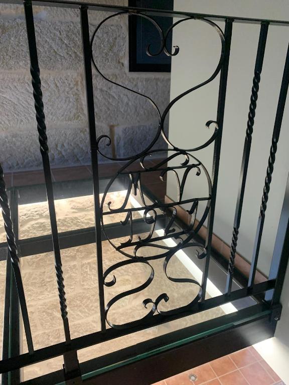 a black iron fence with a bed in the background at Casa 1921 in Quinés