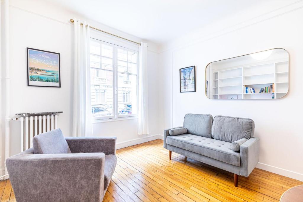 un salon avec un canapé et une chaise dans l'établissement GuestReady - Beautiful Getaway near Eiffel Tower, à Paris