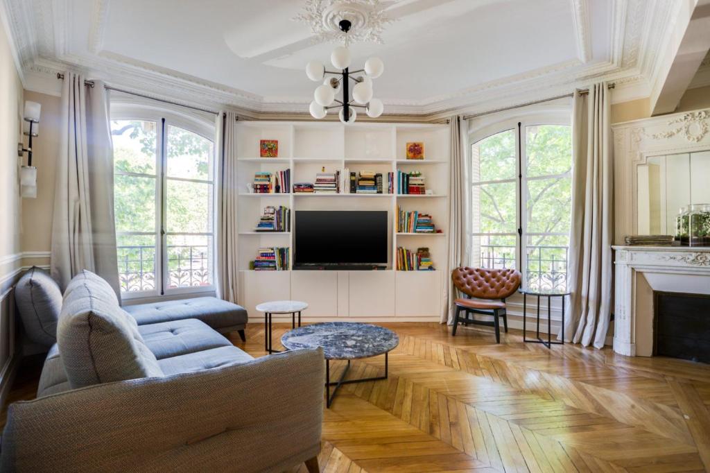 un salon avec un canapé et une télévision dans l'établissement GuestReady - Apt Familial près de la Tour Eiffel, à Paris