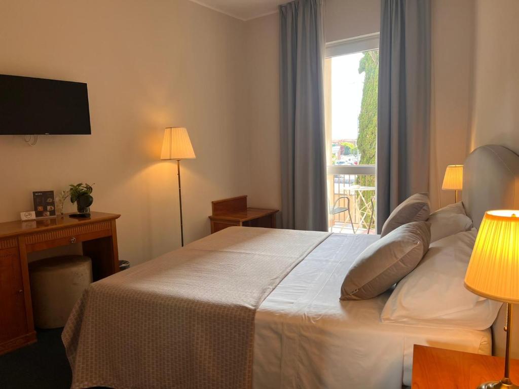 a hotel room with a bed and a window at Hotel Dorè in Castelnuovo del Garda