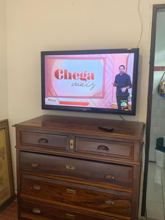 Μια τηλεόραση ή/και κέντρο ψυχαγωγίας στο Casinha 4 quadras da praia com churrasqueira e garagem