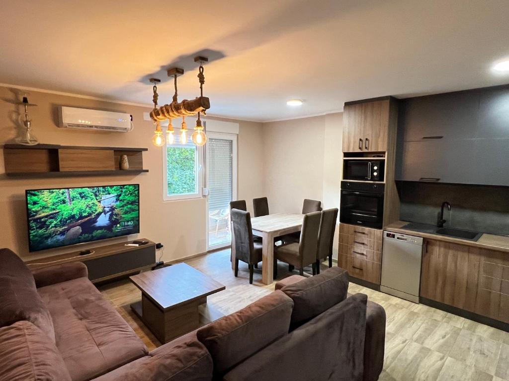 ein Wohnzimmer mit einem Sofa und eine Küche mit einem Tisch in der Unterkunft Apartman Dašić in Jagodina