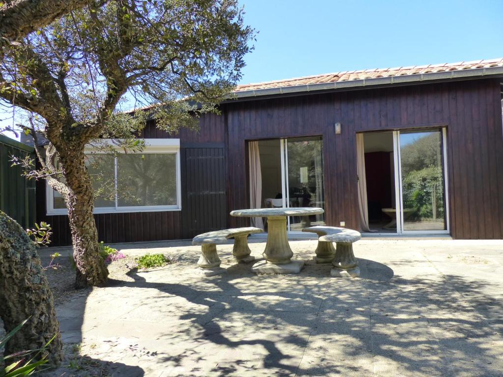 a picnic table and benches in front of a building at HOSSEGOR PLAGE- Villa PAUL -Petite villa rénovée pour 4 personnes- Wifi gratuit in Hossegor