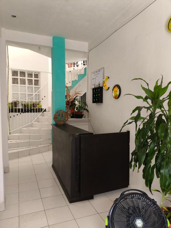 a lobby with a tv and a staircase at Hotel Casa Luna in Palenque